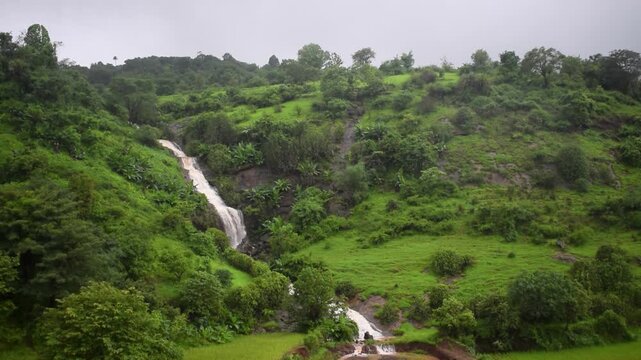 Beautiful natural waterfall through a beautiful roadside green mountain. Tourism, western ghats, lonavala, bhandardara, tamhini ghat, greenery, mountains, hills, river, lakes, milky, sound, trees.