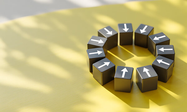 Top view of black cubes arranged in a circle with white arrows pointing inward on yellow surface