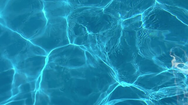 Abstract reflections on a blue swimming pool during daylight in the summer