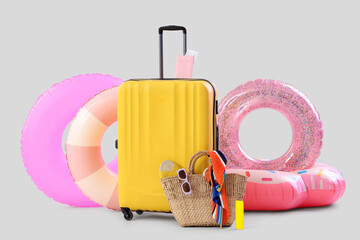 Obraz premium Suitcase, inflatable rings and beach accessories on white background