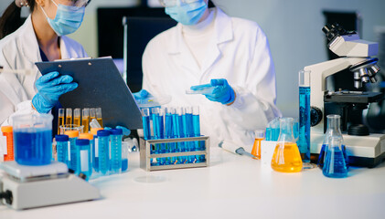 Two female biotechnologists testing new chemical substances in a laboratory.