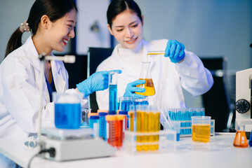 Two female biotechnologists testing new chemical substances in a laboratory.