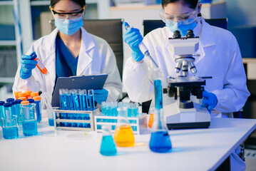 Two female biotechnologists testing new chemical substances in a laboratory.