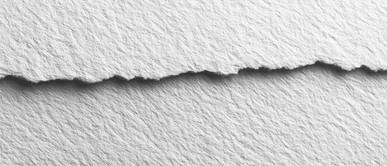 Close-up of textured white paper sheets with a torn edge
