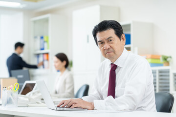 Obraz premium オフィスで働くシニアのビジネスマン