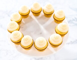 Delicious cupcakes arranged in a circle on a white platter