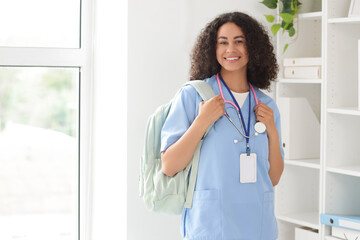 Female African-American medical student with backpack in office