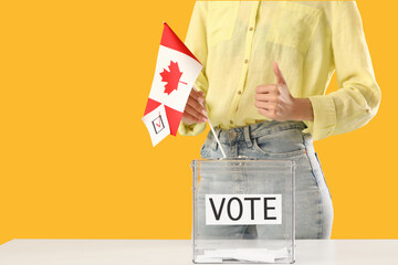 Voting woman with flag of Canada showing thumb-up near ballot box on yellow background