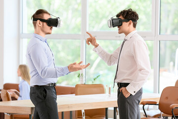 Obraz premium Male business colleagues using VR glasses in office