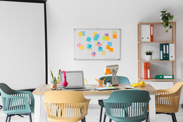 Interior of conference hall with table, whiteboard and shelf unit