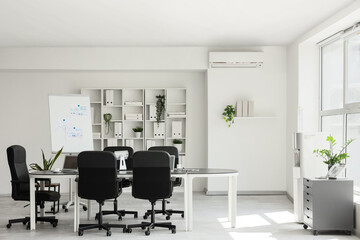 Interior of conference hall with table, flipchart and shelf unit