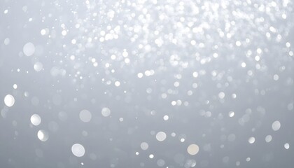 Soft white bokeh light particles floating against a muted gray background creating a dreamy elegant and festive abstract atmosphere