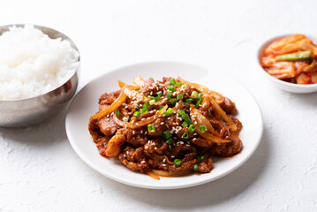 Korean stir fried spicy pork (Bulgogi) with cooked rice and kimchi on white background