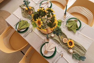 Elegant table serving with plates, candles and beautiful sunflowers