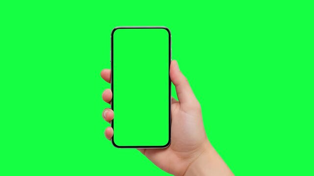 Woman hand holding the smartphone on green screen chroma key background. Phone, green screen, green screen of phone, smartphone green screen, 
animation hand and mobile phone mockup 