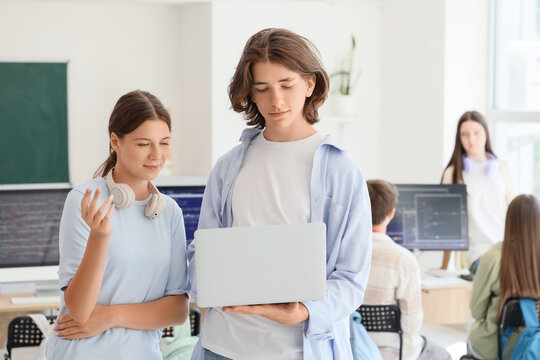 Teenage students studying with laptop at school computer lab