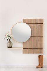 Interior of modern hallway with folding screen, mirror, boots and lily flowers in vase on shelf...