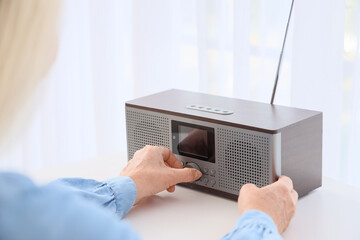 Senior woman turning on radio receiver at home, closeup