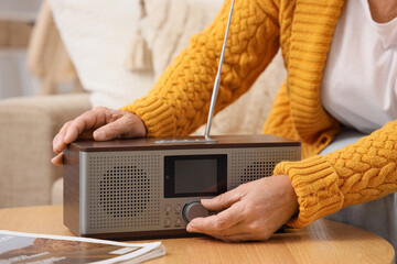 Senior woman turning on radio receiver at home, closeup