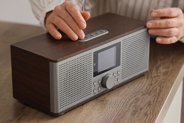 Senior woman with radio receiver on table in kitchen, closeup