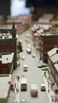 An enchanting aerial view of a meticulously crafted miniature model city street, showcasing intricate details of buildings, tiny vintage cars, and pedestrians in a charming urban diorama