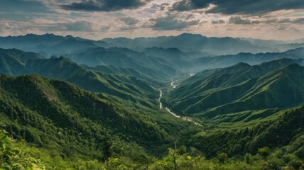 Fototapeta premium Serpentine Valley Road Winding Through Lush, Layered Green Mountains Under a Dramatic Sky.