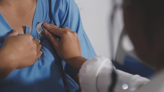 Young doctor is using a stethoscope listen to the heartbeat of the patient. Shot of a female doctor giving a male patient a check up