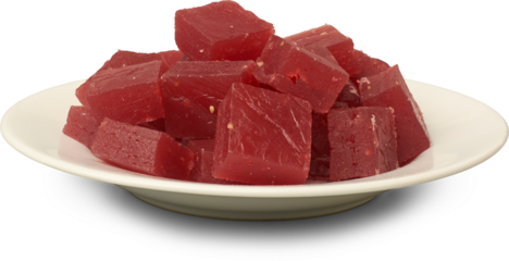 plate of red ghee musket or karachi halwa pieces isolated white background, aka bombay halva, traditional sri lankan or indian chewy sweet dessert 