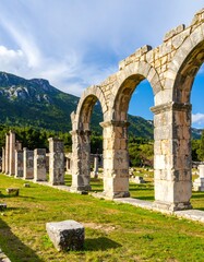 Obraz premium Ancient Greek Ruins, Archways, and Mountainscape in Greece.