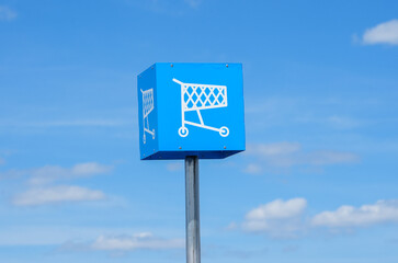 shopping cart sign against blue sky