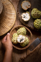 Hand holding a wooden tray of apple custard on an old wooden board, vintage still life style.