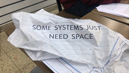 Crumpled note with informative text on workspace table