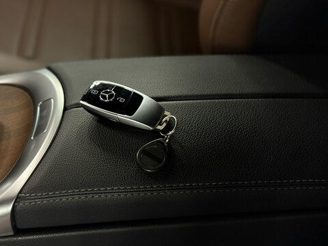 SUV Mercedes G-class AMG G 63 interior and key. Car key remote door opener with a leather keychain from a Mercedes G-class AMG G 63 lying on the leather armrest. 