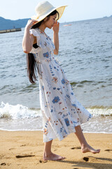 夏の百道浜を歩く若い女性