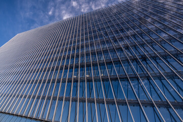 A view from below of a glass building wall.
