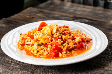 Omelette with tomatoes on a dark background.Asian food. Chinese cuisine