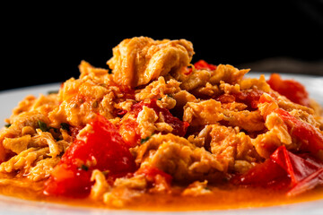 Omelette with tomatoes on a dark background.Asian food. Chinese cuisine