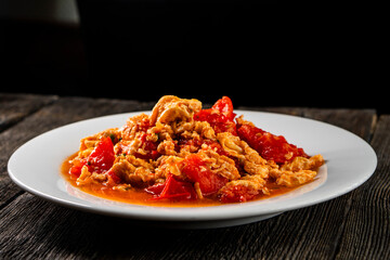 Omelette with tomatoes on a dark background.Asian food. Chinese cuisine