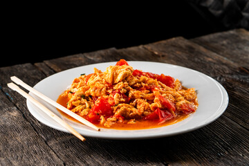 Omelette with tomatoes on a dark background.Asian food. Chinese cuisine