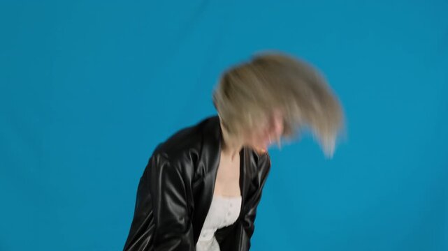 Frustrated young female bends down holding hands near head. Blonde woman shakes hair pointing finger at annoying opponent slow motion