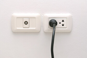 Power plug connected to wall outlet in room