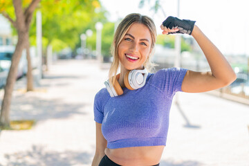 Young pretty sport woman at outdoors doing strong gesture