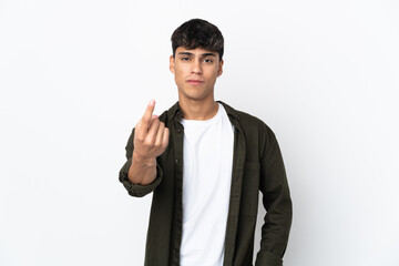 Young man over isolated white background doing coming gesture