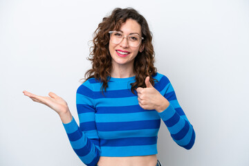Young caucasian woman isolated on white background holding copyspace imaginary on the palm to...