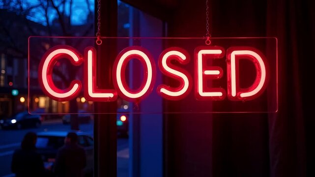 Bright red neon 'CLOSED' sign glowing in a storefront window at dusk