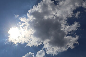 Sun shining through clouds on beautiful blue sky