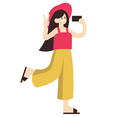 A cheerful young woman in a red hat and yellow pants takes a selfie while making a peace sign.