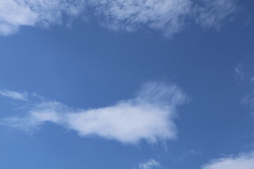 White clouds drifting across a vibrant blue sky on a sunny day