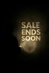 Sale ends soon message illuminated by flashlight in dark moody wall background minimal marketing banner for retail promotion countdown and urgency