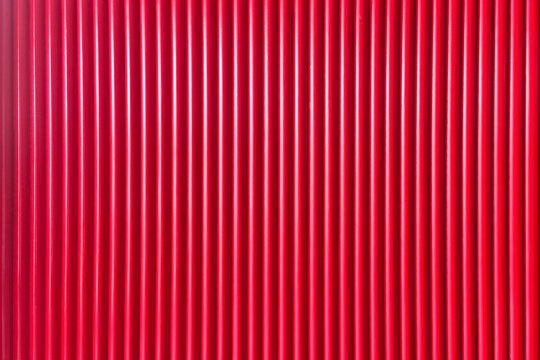 Vibrant red corrugated metal texture with vertical ridges, ideal for industrial design, architectural backgrounds, and graphic overlays. This seamless pattern offers a bold, modern aesthetic suitable